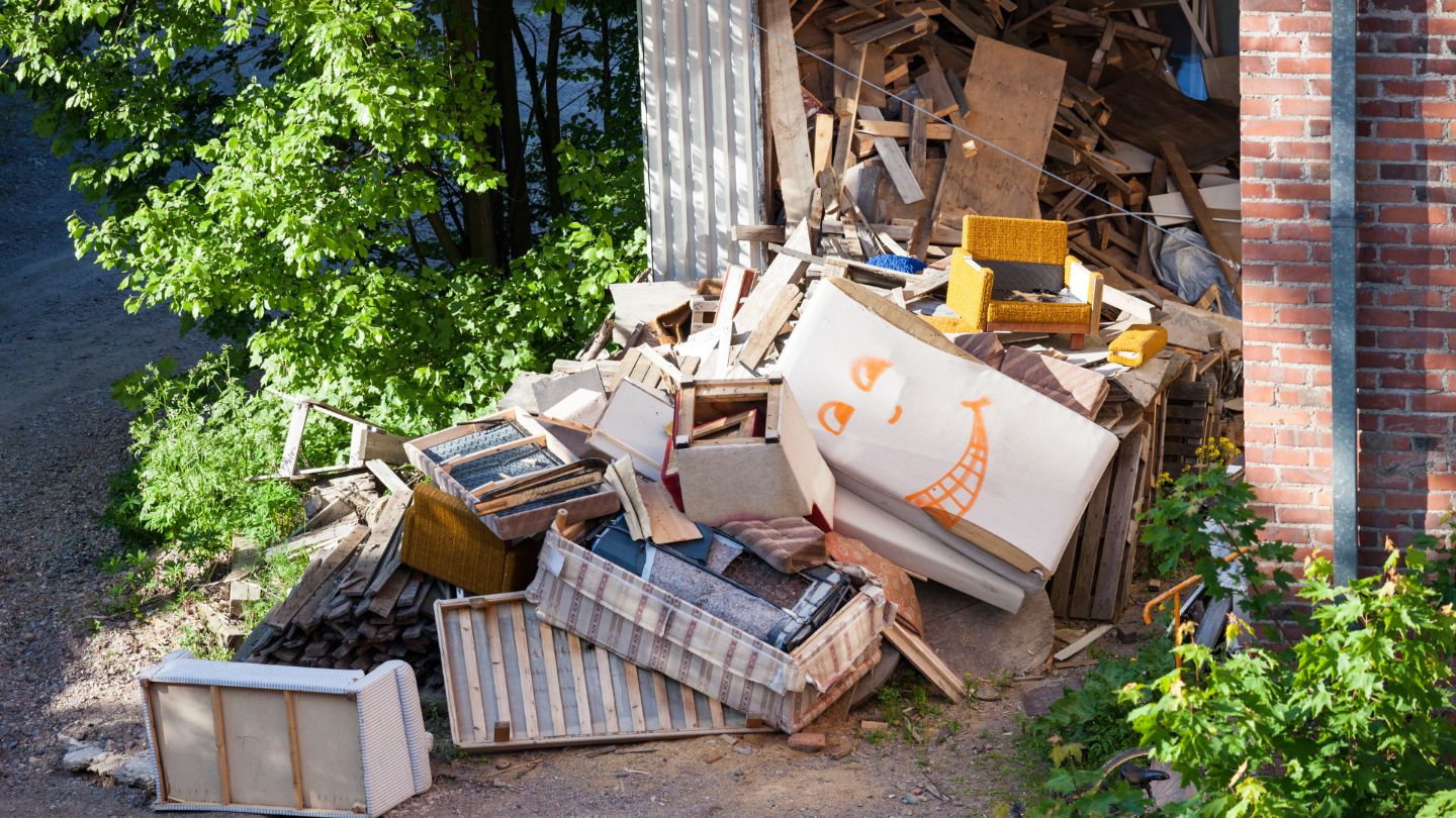 Large pile of junk and debris including furniture and construction materials